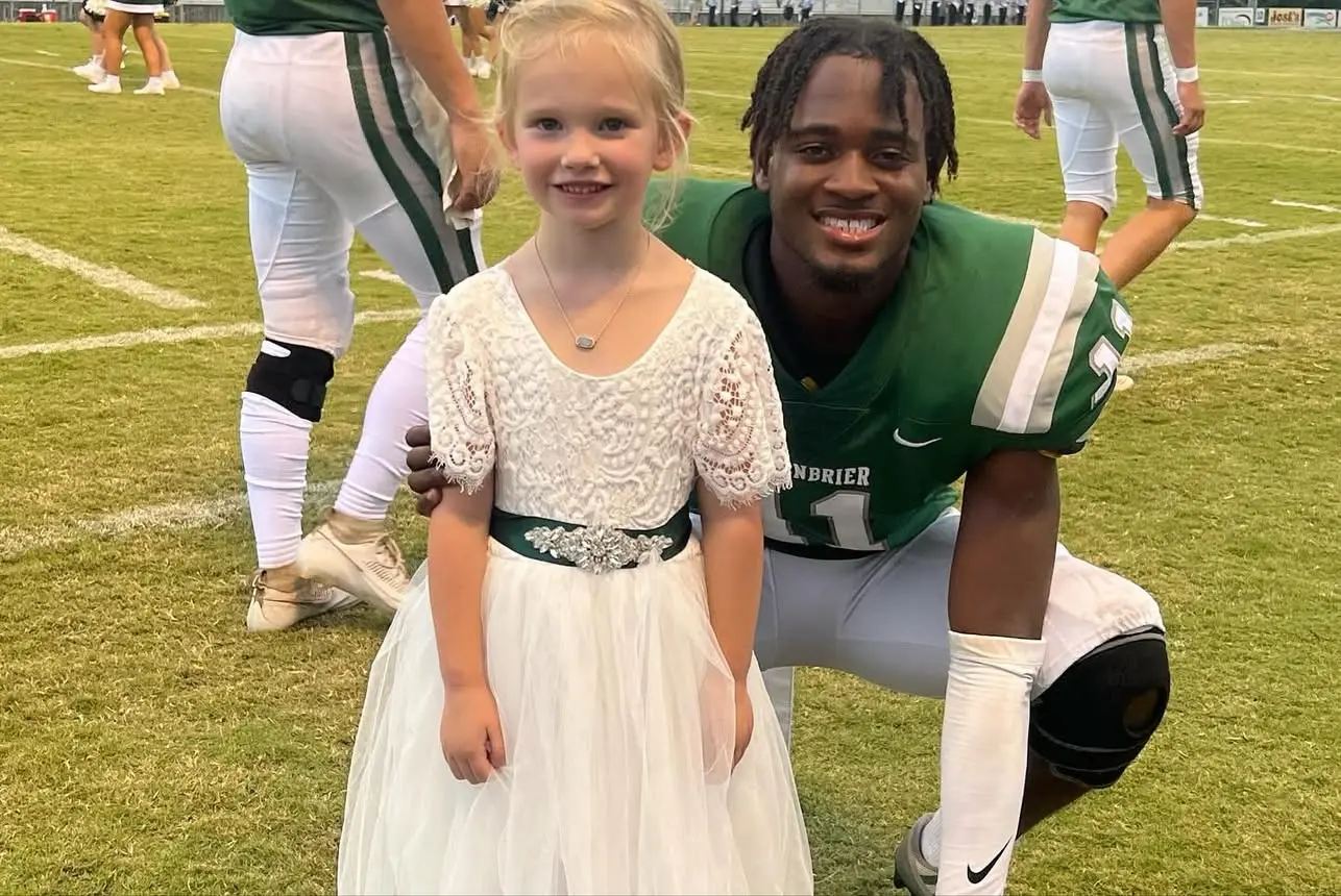 Parker Jade Sorrells in her junior-attendant dress with a Greenbrier football player